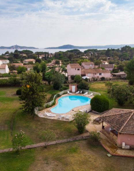 Vista aerea di una piscina in un paesaggio rurale con colline e mare.